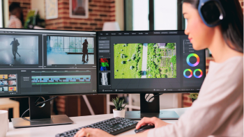 persoon met hoofdtelefoon voor twee beeldschermen met video's en soundtrack